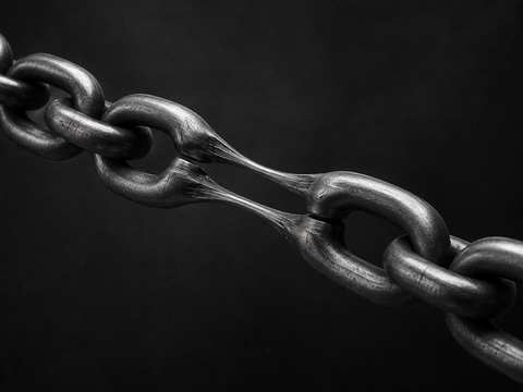 Black and white 3D render of a chain stretched until its links lengthen