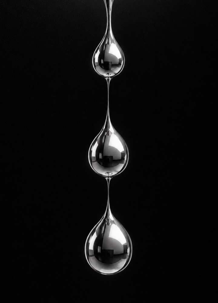 Black and white 3D render of liquid chrome drops hanging on thin strands